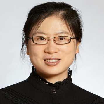 A portrait of an Asian woman in her 30's with glasses and black hair (bound up), wearing a black dress or shirt closed up to her neck