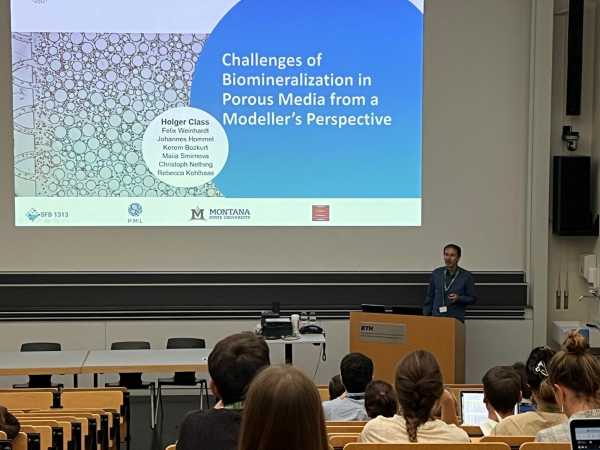 a man presenting in a lecture hall setting