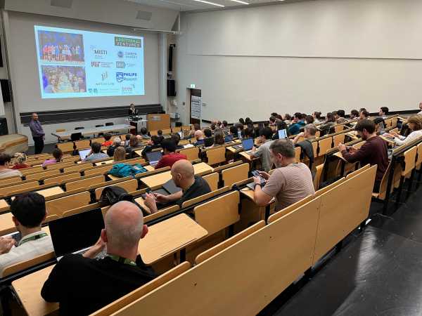 A big lecture hall in session. The audience seen from behind.