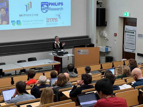 A woman in front of a lecture hall audience