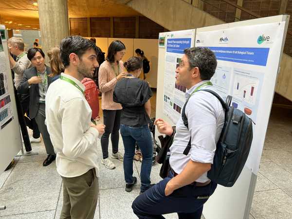 People standing in front of research posters discussing