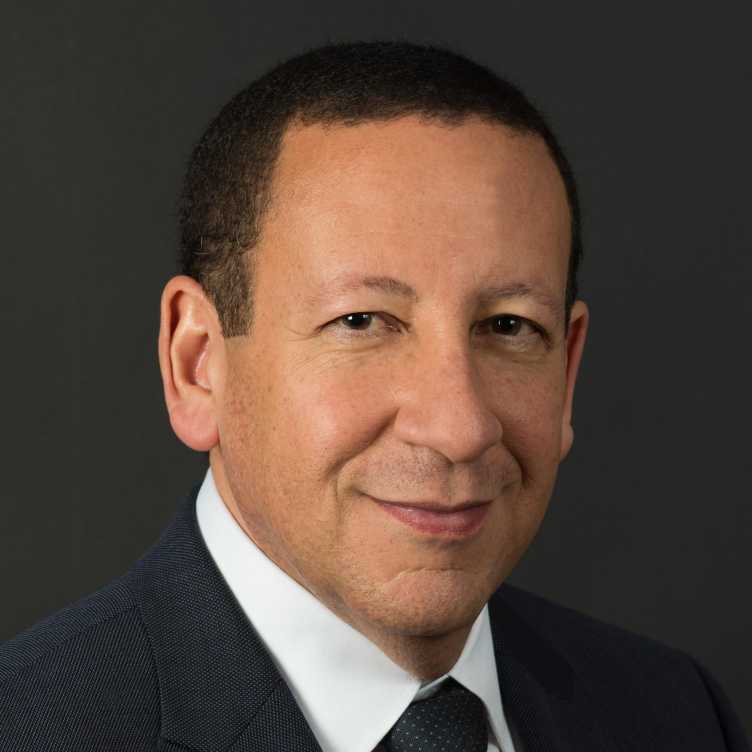 Headshot picture of a man wearing a white shirt and a tie