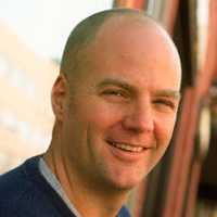 Headshot picture of a smiling bold caucasian man